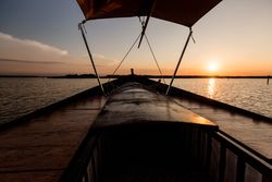 Front of boat riding along sea
