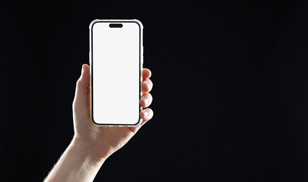 Hand holding smartphone on dark background
