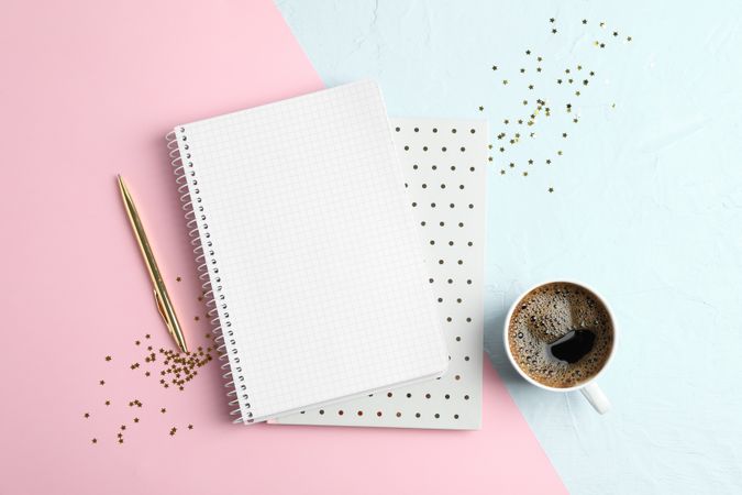 Cup of coffee with copybooks, glitter stars and pen on color background, space for text