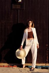 A long hair fashion model with a hat at the beach with a dark background