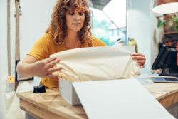 Saleswoman gift wrapping customer’s purchase