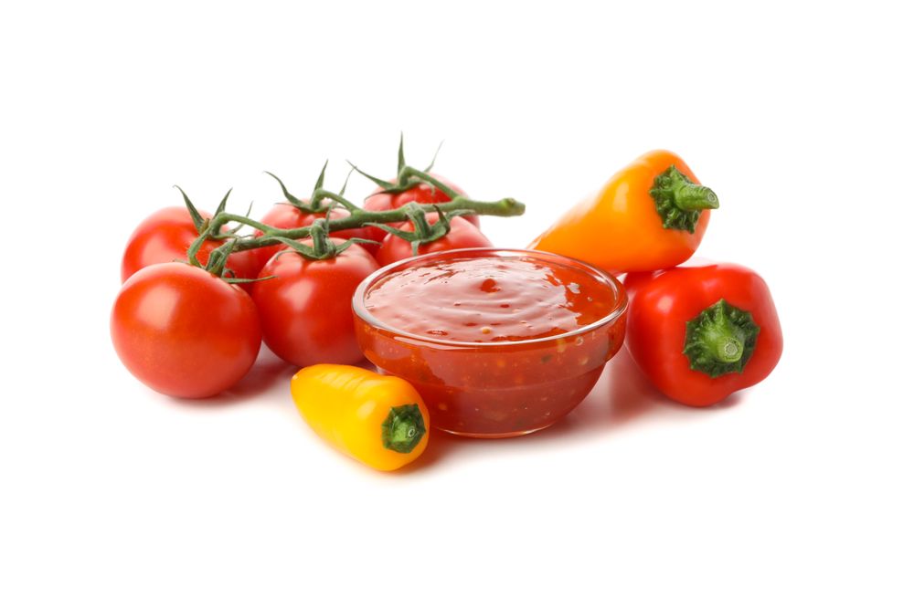 Branch of tomatoes, pepper and sauce isolated on plain background