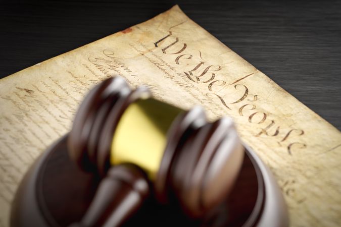 United States Constitution and Gavel Resting on Table.