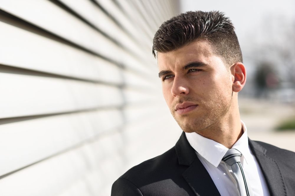 Handsome man in suit next to wall