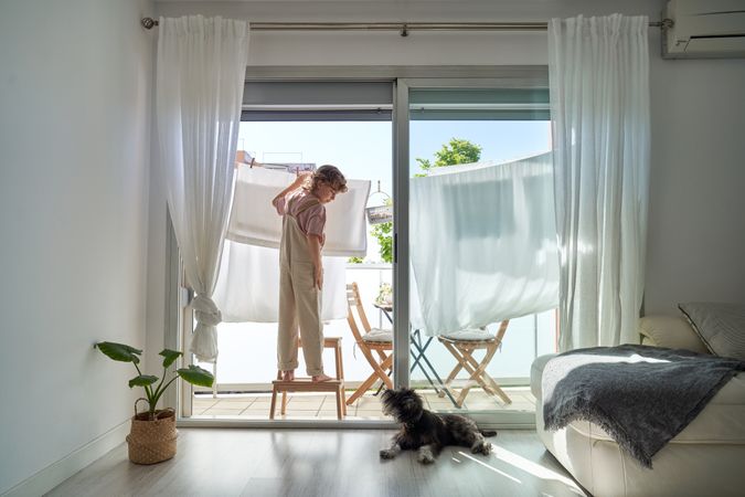 Kid hanging linen on clothesline at home