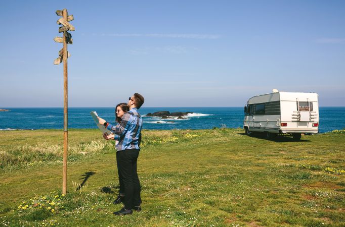 Young couple looking a map and direction sign