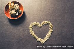 Dried marijuana in the shape of a heart and wooden container of bud 4mZrNb