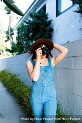 Female photographer in hat and denim one piece 4NKLDb