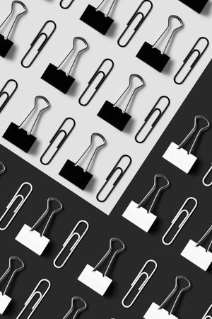 Binder clips and paper clips on monochrome paper