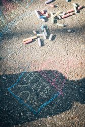 Colored chalk on pavement in sunny day