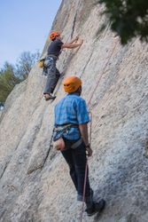 Climbers in safety harness climbing mountain