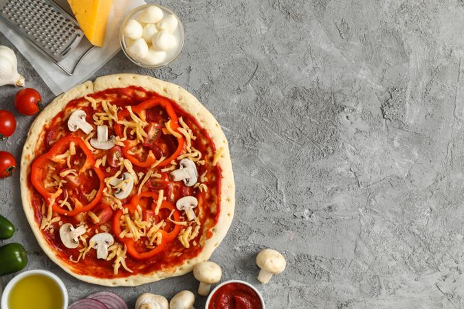 Concept for cooking pizza with ingredients on gray table