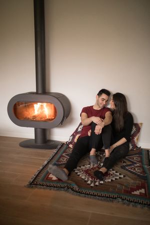 Couple sitting near fireplace on floor