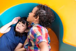Two children playing in bright kindergarten room