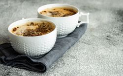 Side view of cups of morning coffee on grey counter