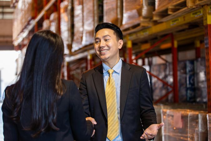 Smiling Asian professional male shaking hands of female colleague