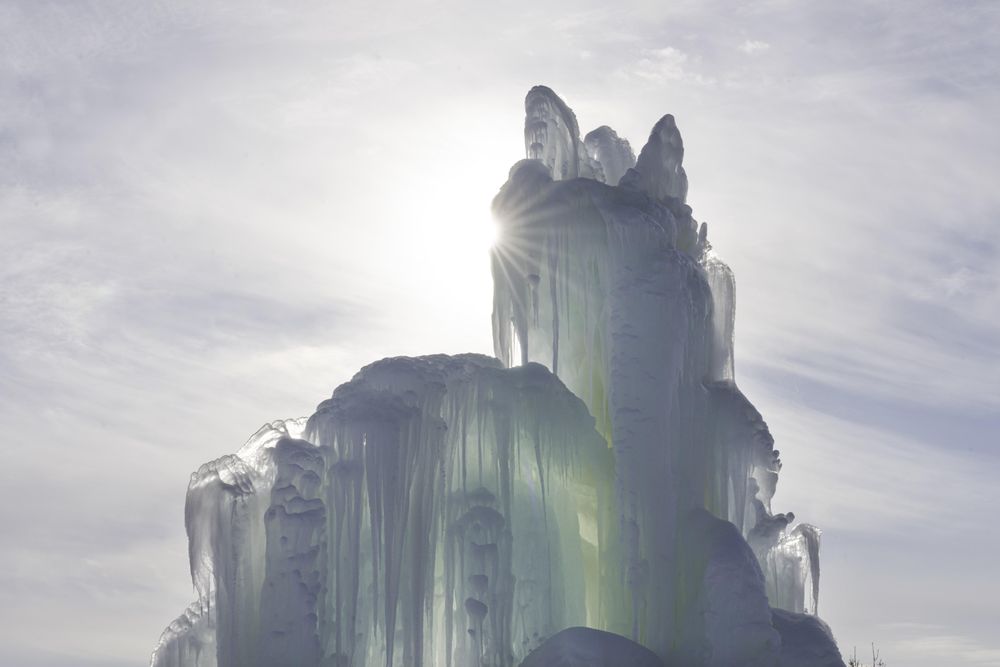 Sun rays shining through a blue ice structure