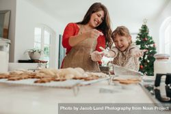 Mother and daughter having fun while baking for Christmas 0yXwdq