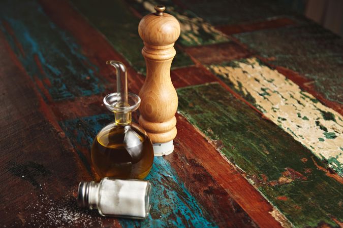 Salt, pepper and oil on wooden table, horizontal view