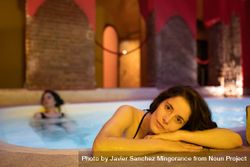 Woman resting head on side of bath in spa 5wDOR4