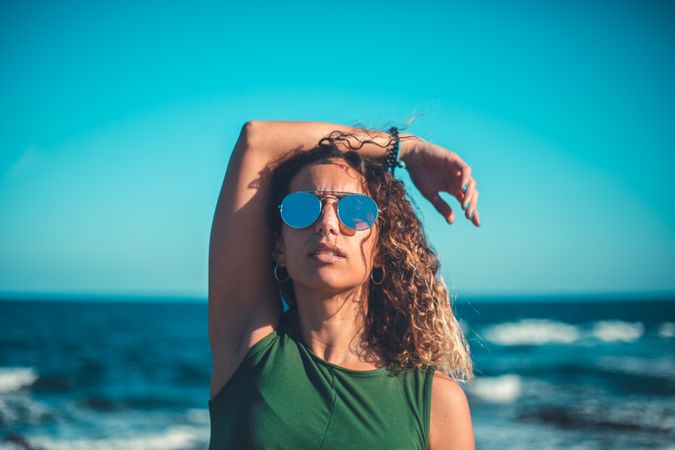 Stylish woman standing near sea