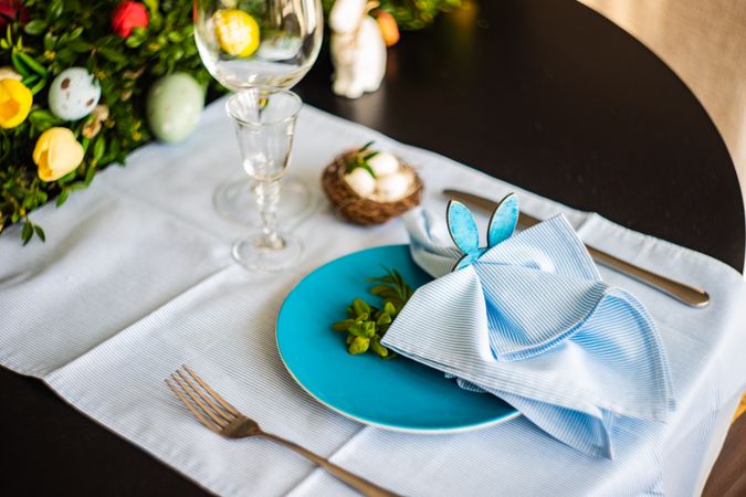 Easter table setting with rabbit napkin ring on pastel blue napkin and plate
