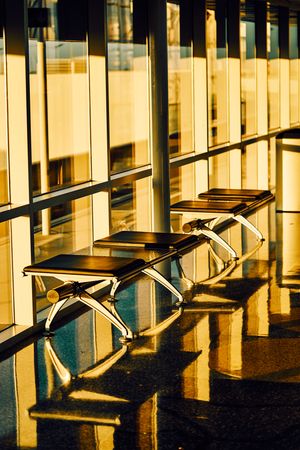 Long bench with soft seat nearby glass wall