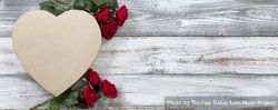 Happy Valentine’s Day with heart shape gift box and red roses on aged wood 47AP60