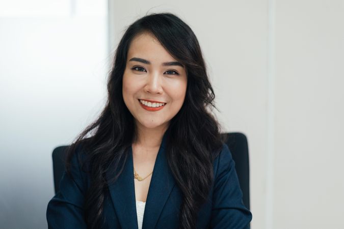 Smiling Asian woman sitting in business casual