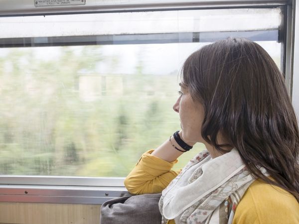 Woman traveler looking through window inside of suburban train