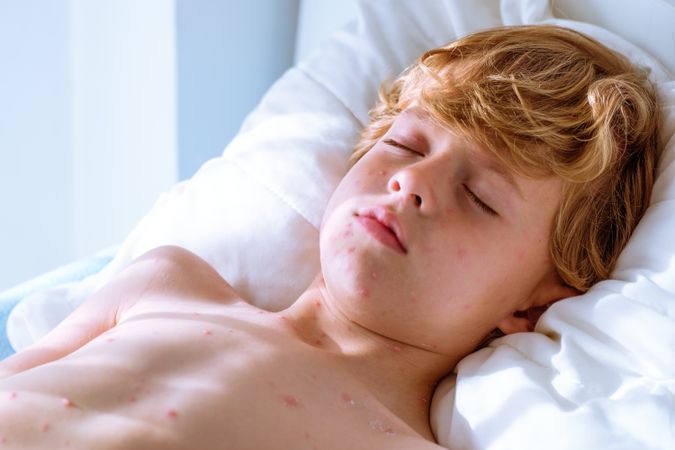 Sick boy sleeping on bed
