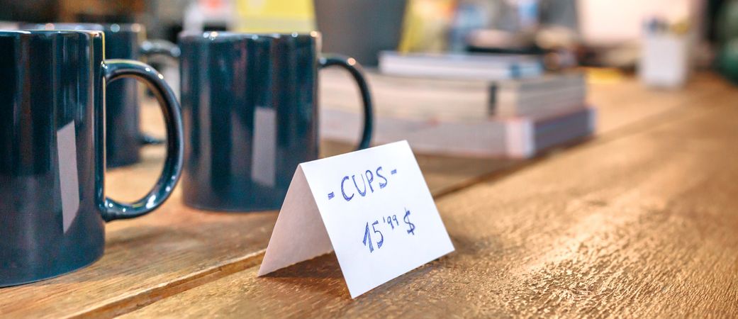 Banner of articles price label over wooden counter in local store with industrial style decoration