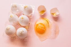 Easter eggs in box and broken egg on table