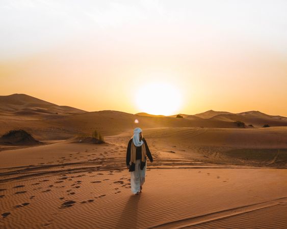 Woman walking in the desert during golden hours