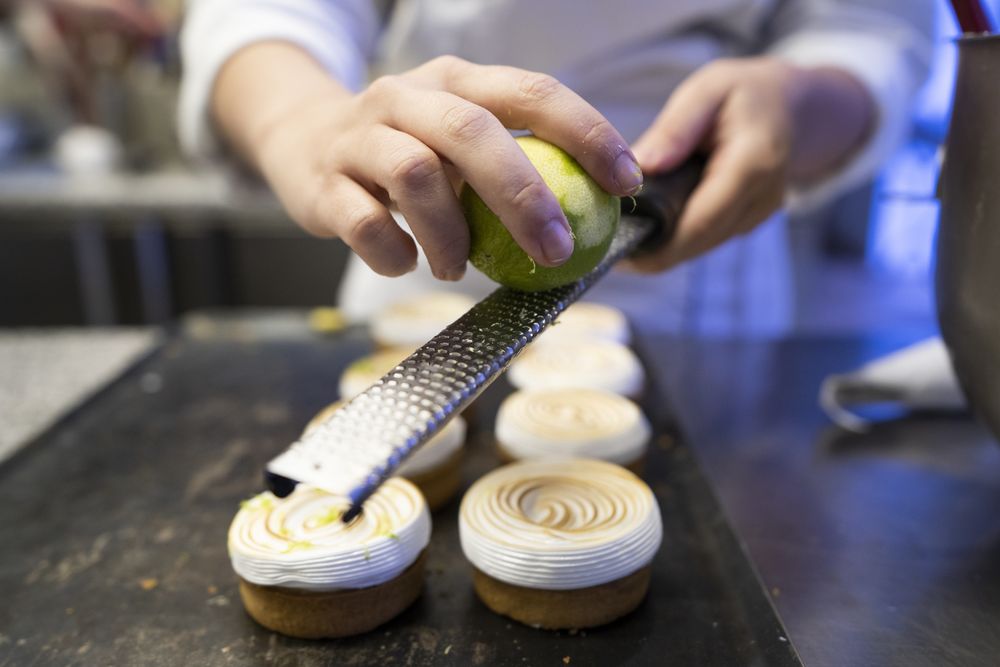 Cook grating lime on meringue cookies