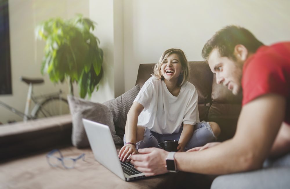 Couple browsing laptop on couch