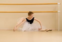 Ballet dancer stretches gracefully on the studio floor