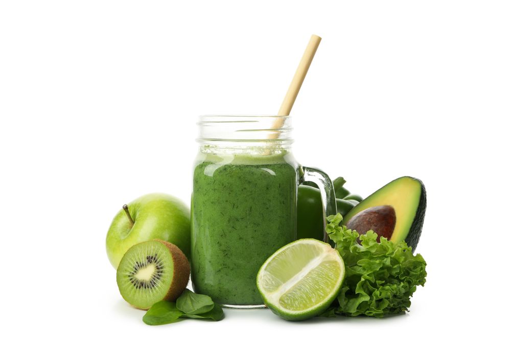 Green vegetables, fruits and jar of smoothie isolated on blank background
