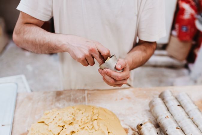 Unrecognizable cook putting pastry dough in cup