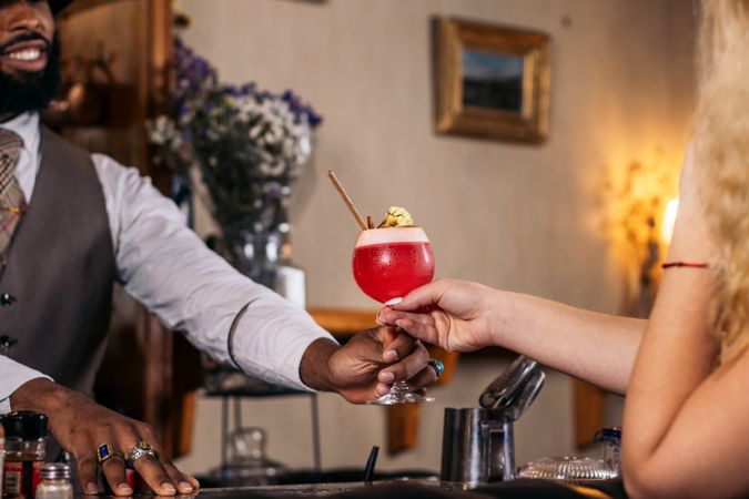 Stylish bartender offering a cocktail