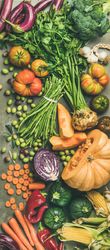 Fresh produce on concrete background, with halved squash, corn, cabbage, vertical composition