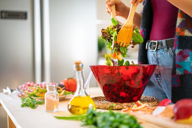 Crop woman preparing vegetable salad