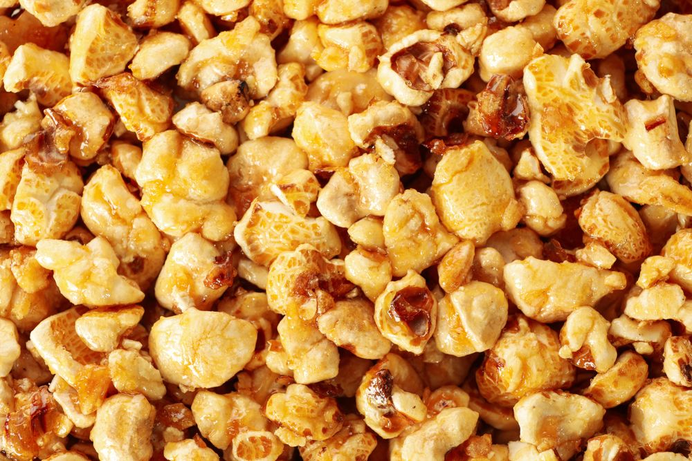 Tasty peanut brittle on whole background, close up