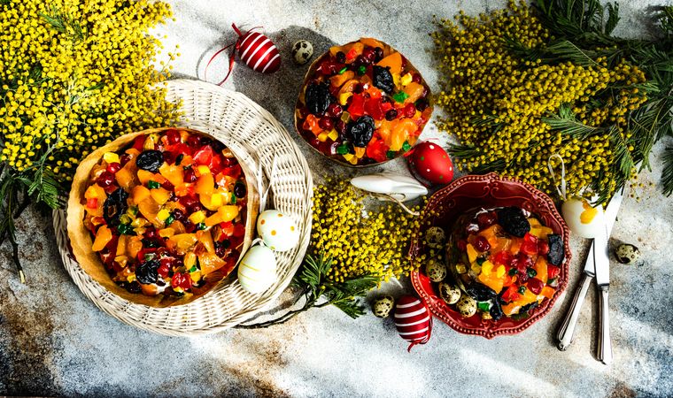 Top view of Easter fruit cakes with decorative eggs and yellow flowers