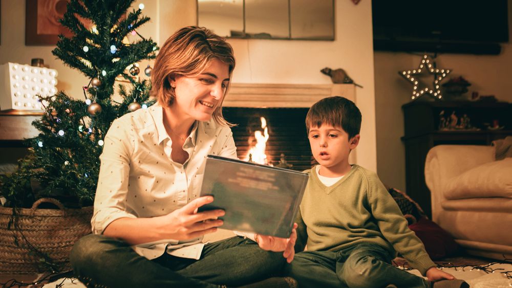 Mother reading book with son on Christmas eve