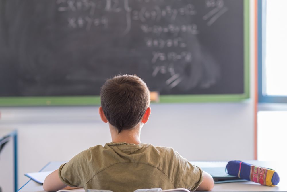 Back of teenager sitting in classroom