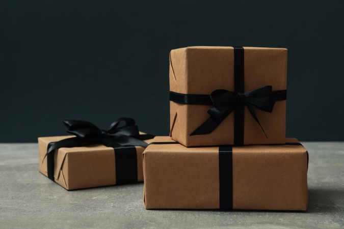 Craft gift boxes with bow on gray table against dark background
