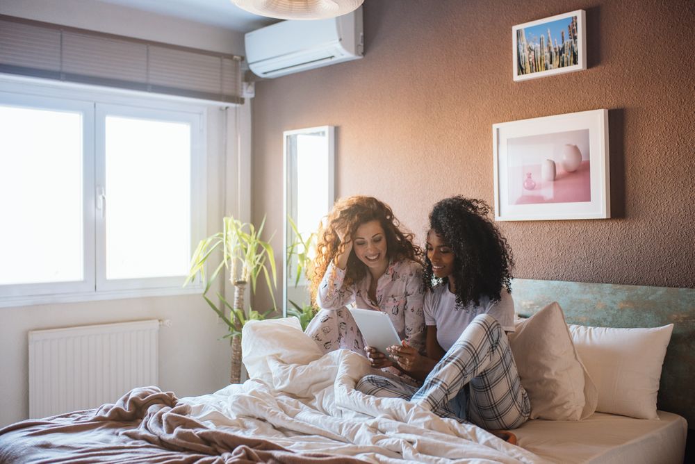 Women in bed entertained on their tablet