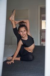 Flexible girl stretching body on bed