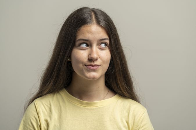 Young woman with natural skin texture looking sideways in thoughtful portrait for authentic beauty shot